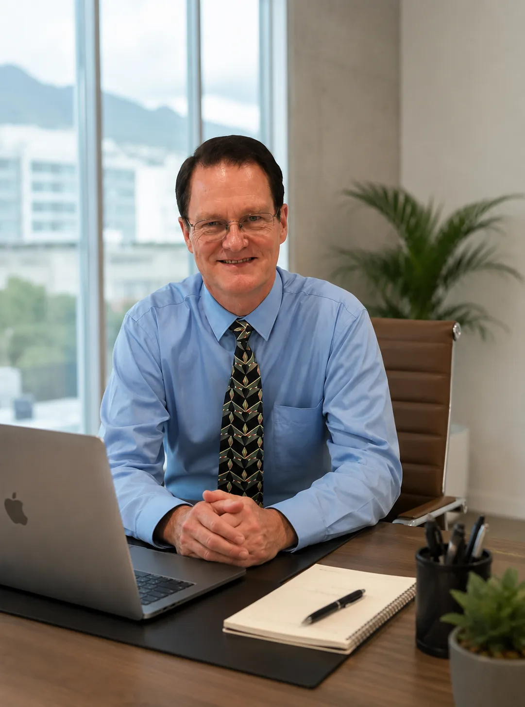 Teacher John smiling at his desk